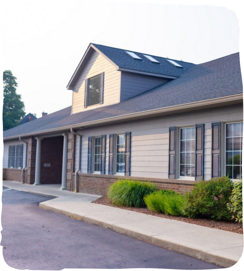 Modern pediatric dental office building with brick and siding exterior, landscaped front entrance.